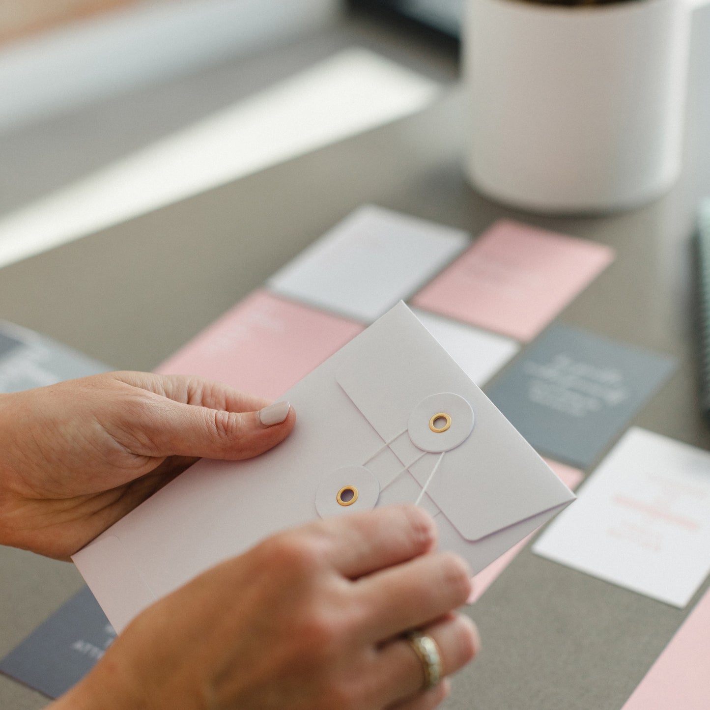 the cards come in a string and washer envelope the images shows hands opening the envelope